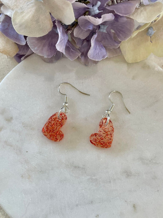 Clear hearts with red glitter off center heart drop earrings