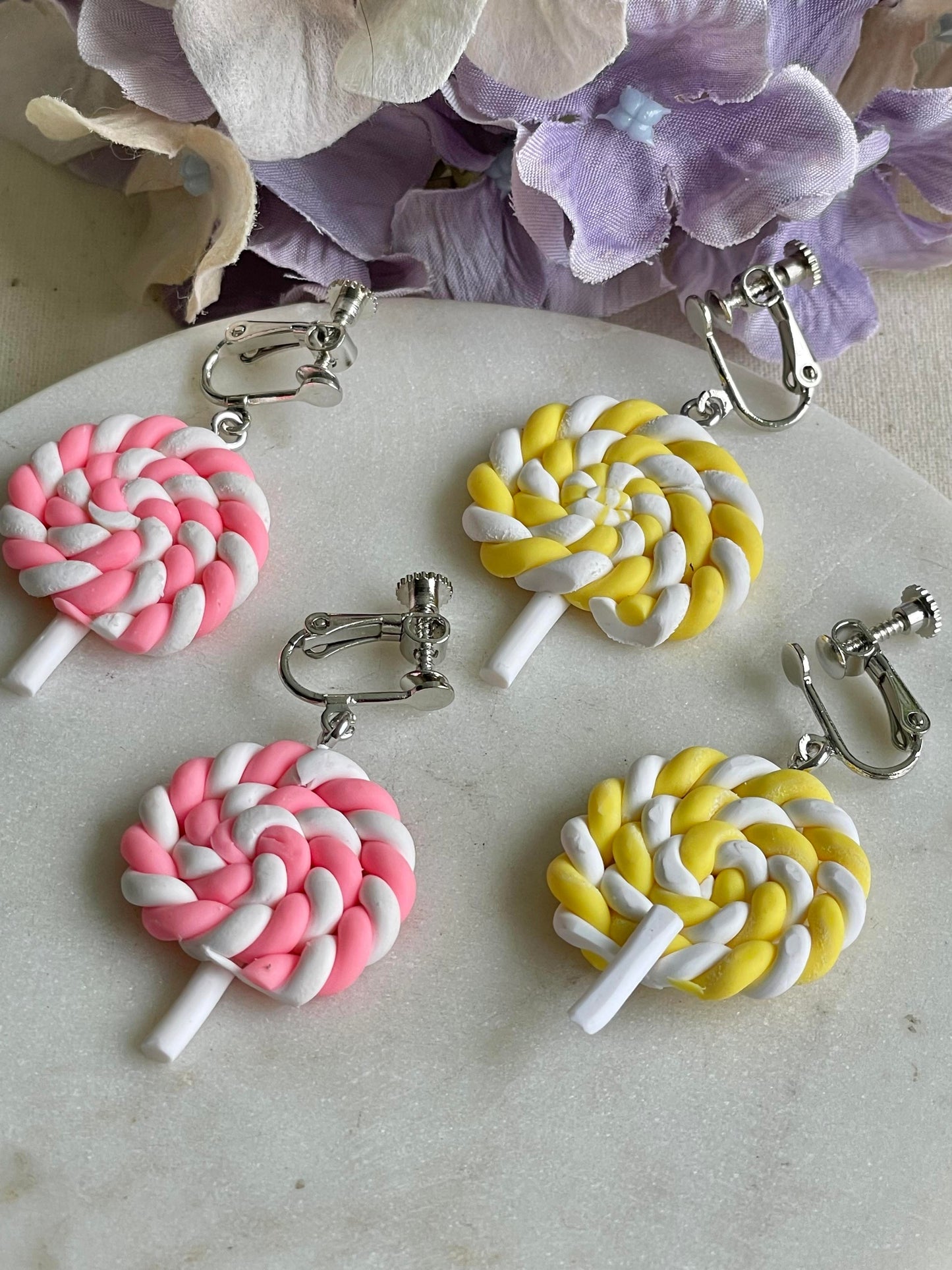 Twisted yellow lollipop clip on earrings