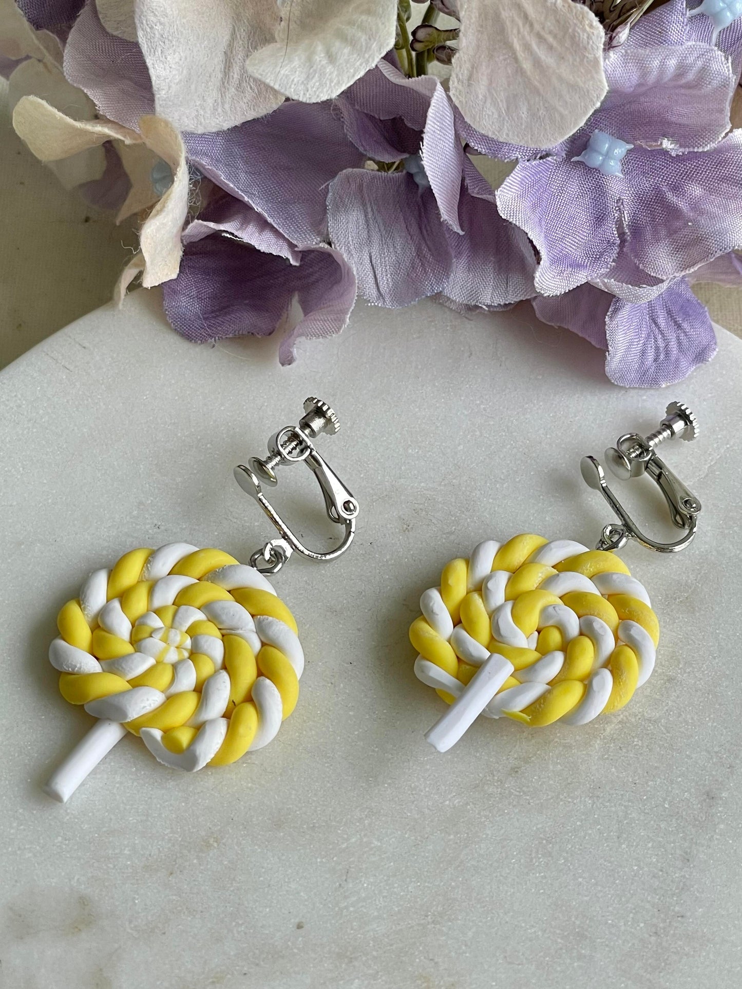 Twisted yellow lollipop clip on earrings