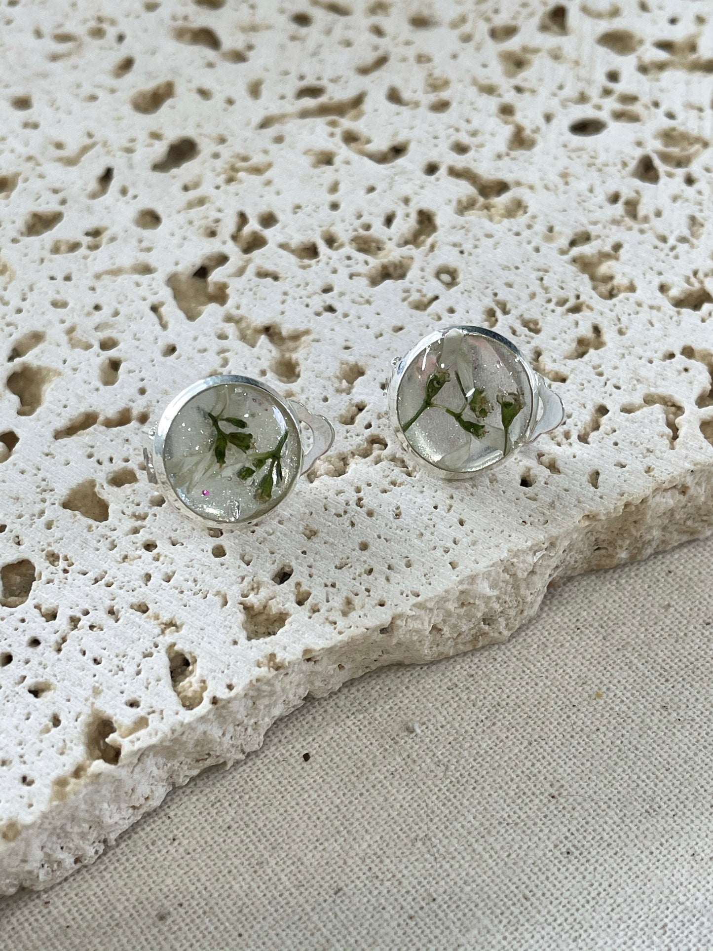 Silver clip-on earrings with small white flowers